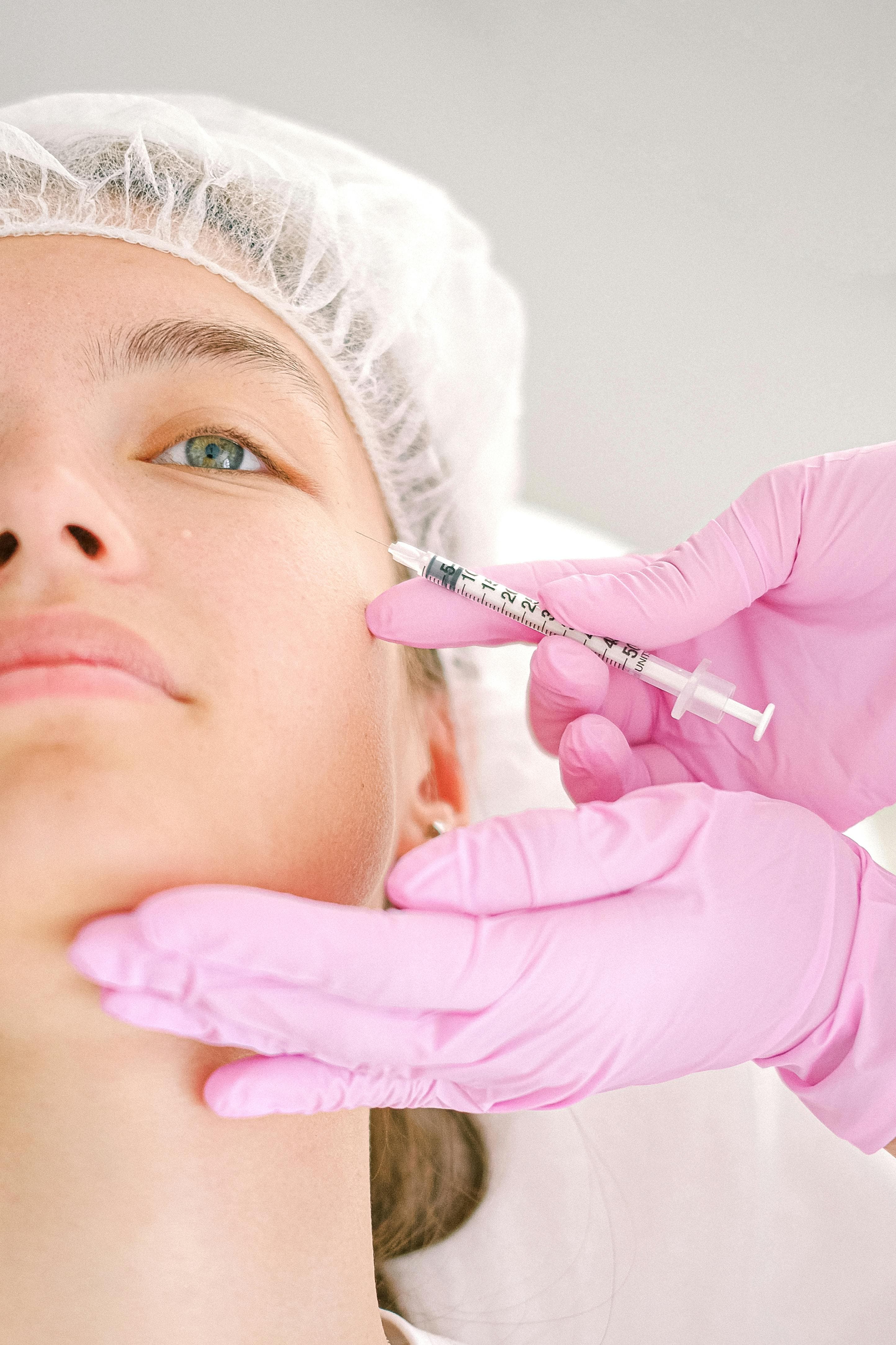 Practitioner administering a facial aesthetic treatment to a patient